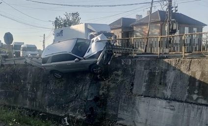 Șofer norocos: A lovit balustrada unui pod, iar mașina i-a rămas suspendată deasupra apei