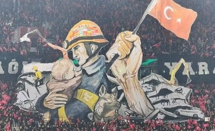Scenografie emoționantă a fanilor lui Trabzonspor: un pompier ține în brațe un bebeluș scos dintre dărâmături. Pe casca salvatorului sunt steagurile țărilor care au ajutat Turcia după cutremur